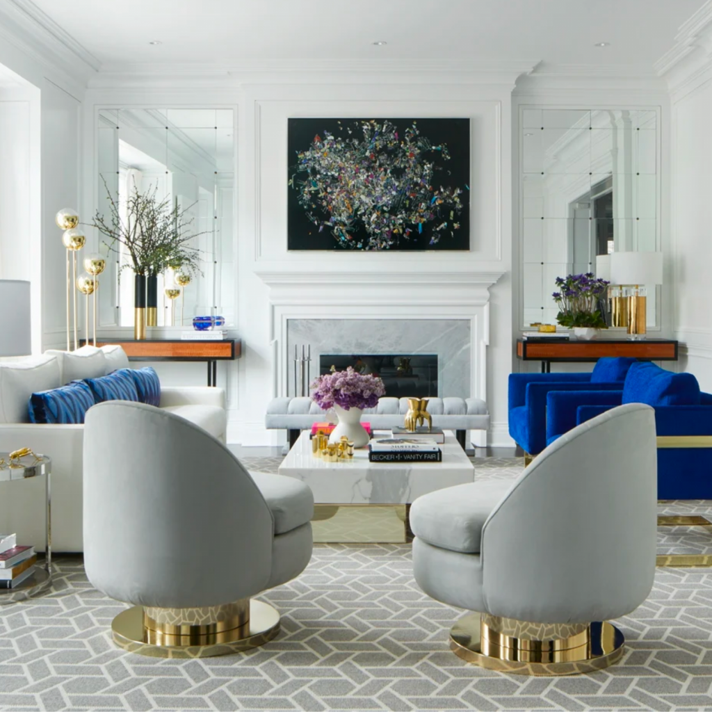 A transitional living room with a custom built fireplace and cold tone color palette. The skilled contractor also flanked artfully curated mirrors to flank the fireplace.