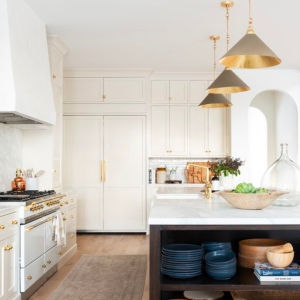 Kitchen design by Studio Mcgee in a white cabinetry contrasted by a black island.